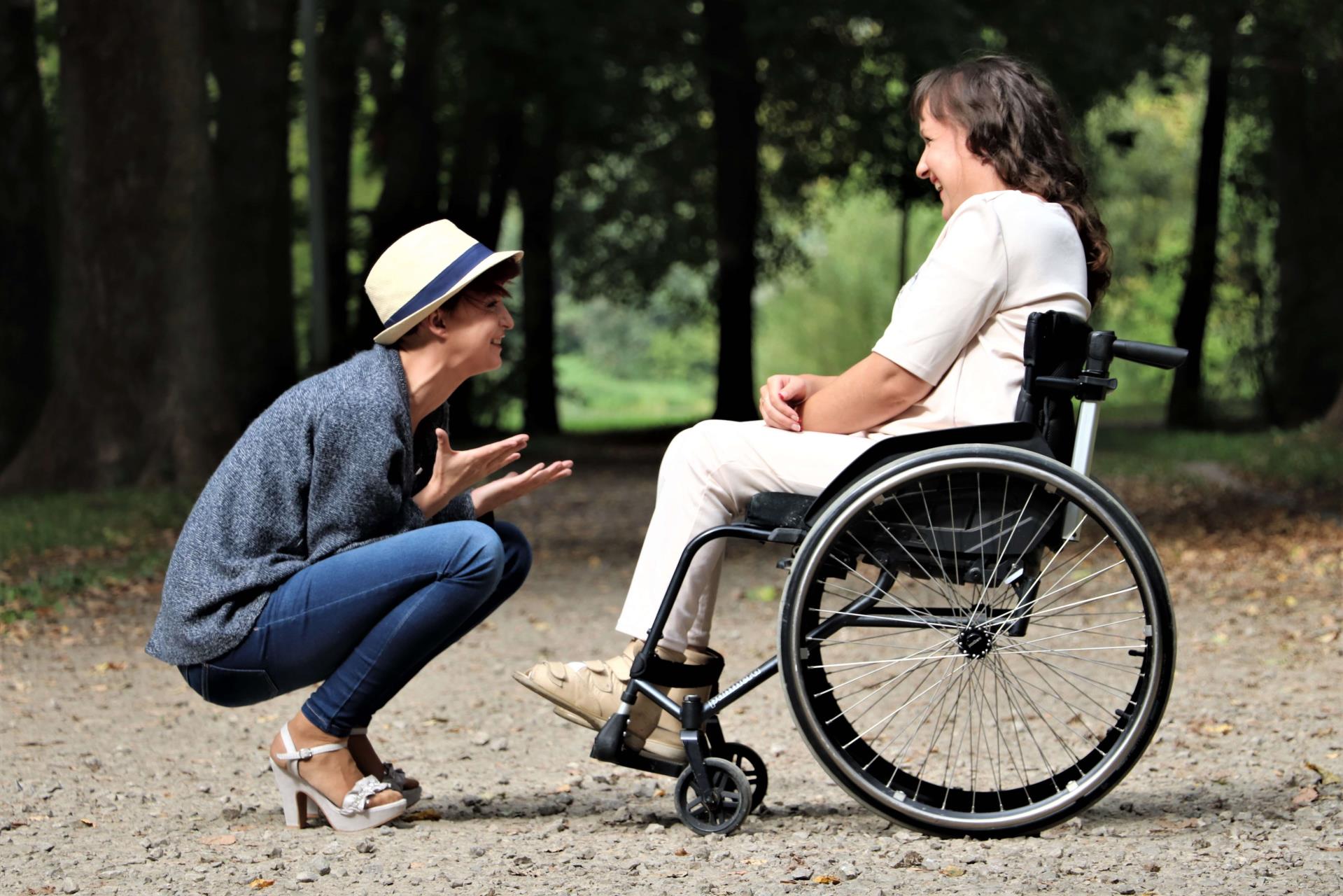 lady in wheelchair with lady squatting beside her