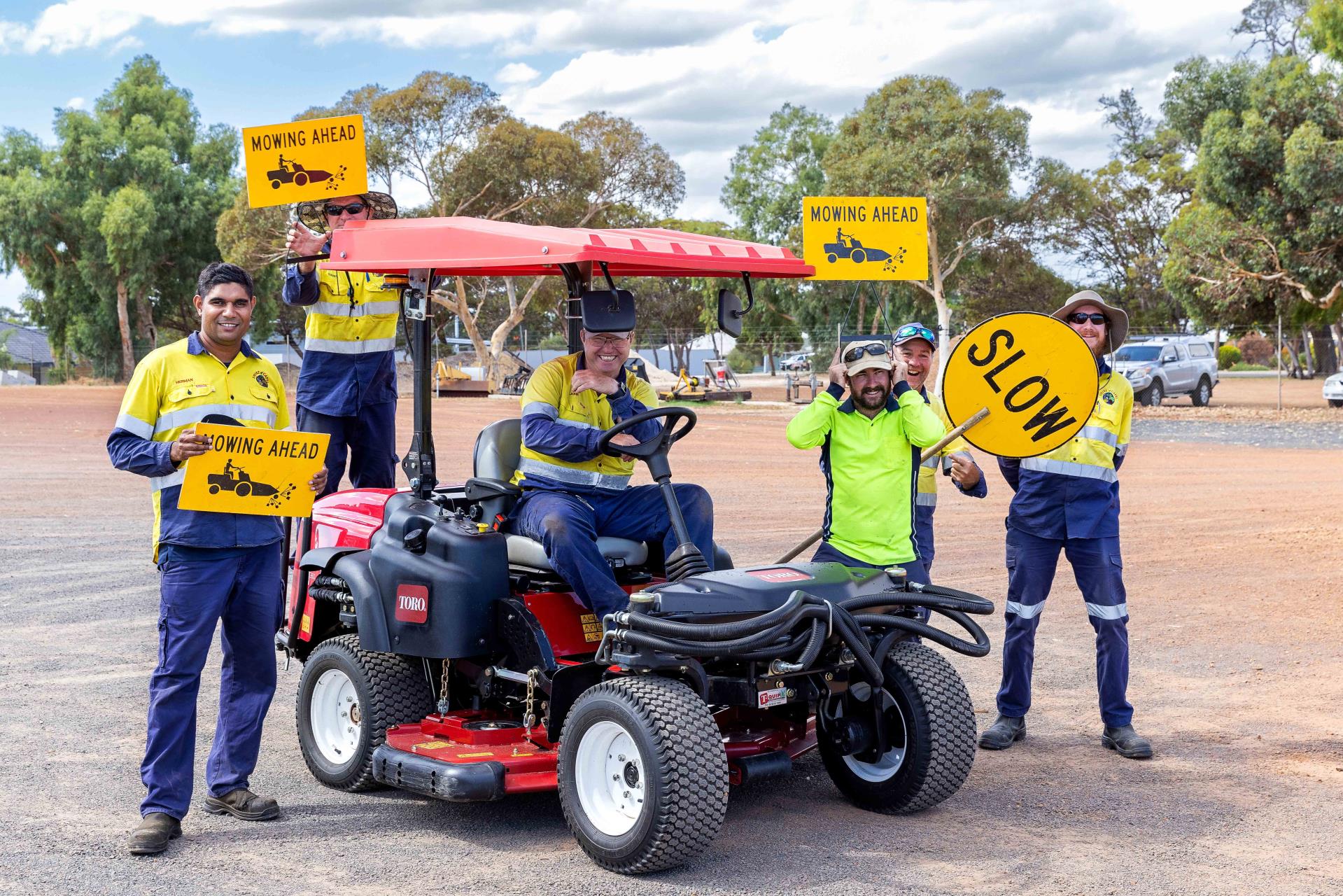 various workers holding signs with ride on mower