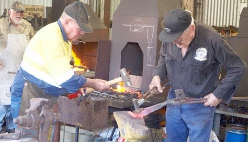 two men working in front of Kiln on metal products