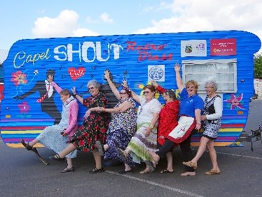 group of ladies infront of Van dancing