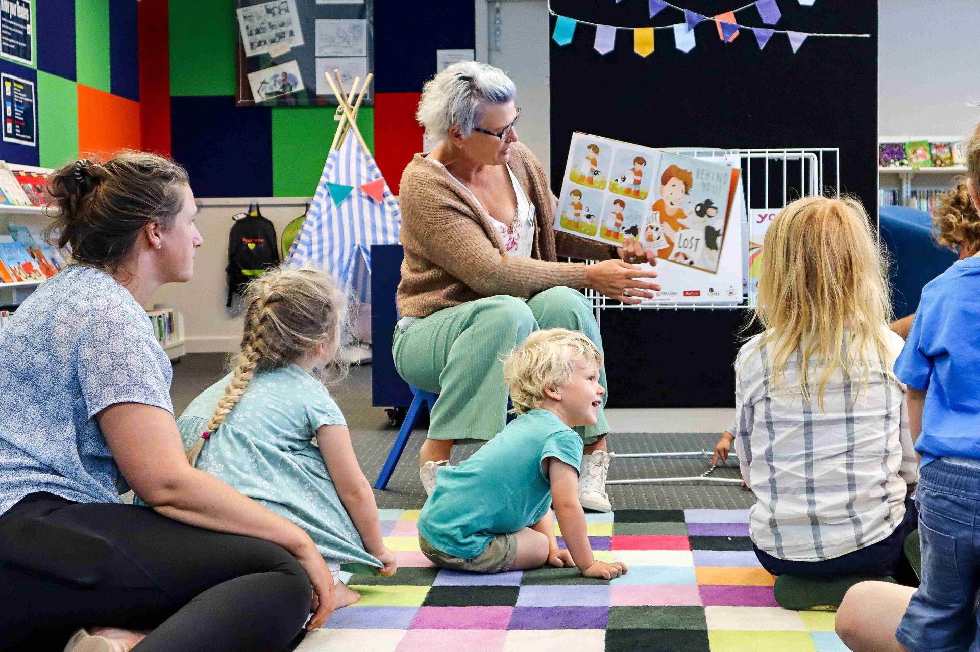 Lady reading book to children