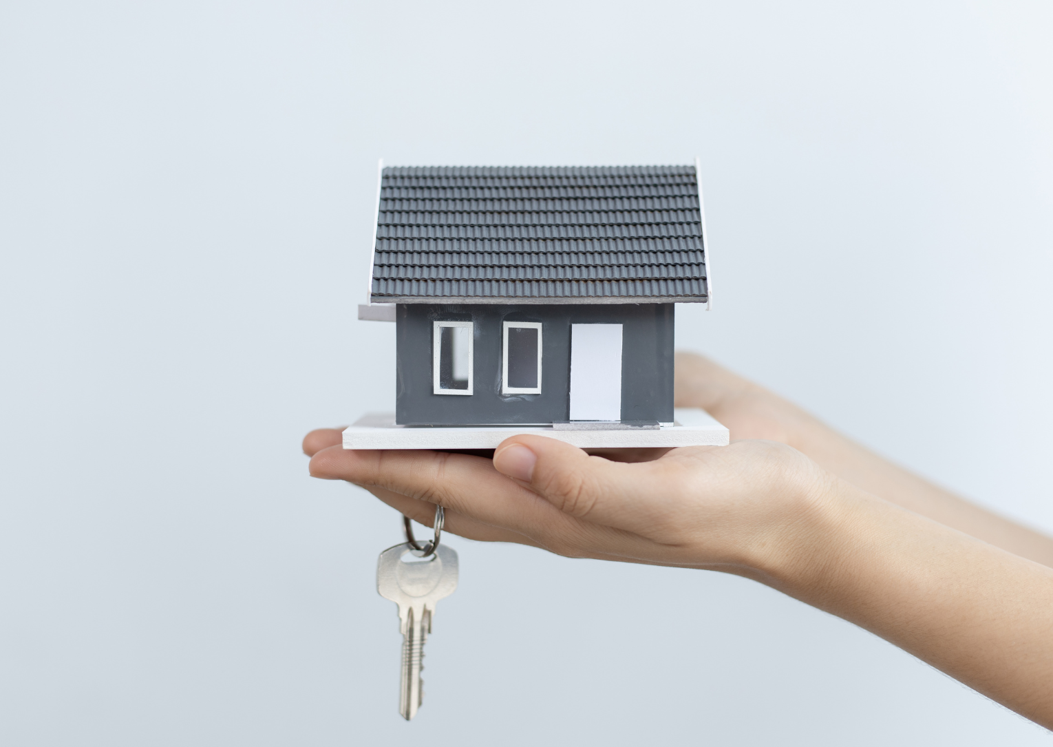 Small house in palm of hand with key
